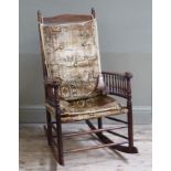 A spindle back rocking chair with upholstered cushion back and seat
