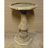 A cast concrete bird bath of octagonal outline and baluster pedestal and stepped base