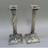 A pair of silver plated Corinthian column table candlesticks with beaded nozzles and stem spiral