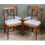 A set of four Sheraton style mahogany dining chairs, the concave cresting rails inlaid with