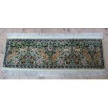 A Caucasian multicoloured rug worked with beasts, birds and trailing leafage on a pale green ground,