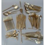 A suite of bronzed cutlery including cake slice, serving spoons, salad servers, ladle, butter