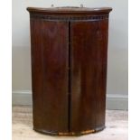 A 19th century mahogany bow fronted two door corner hanging cupboard