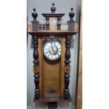 A late 19th century walnut wall clock with architectural pediment cream enamel chapter ring with