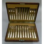 A set of twelve continental mother of pearl handled fruit knives and forks engraved blades stamped