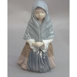 A Nao figure of a kneeling young girl wearing a shawl, 24cm high, printed mark in brown
