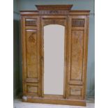 A Victorian pollard oak wardrobe with stepped dentil moulded cornice, fluted frieze centred on a