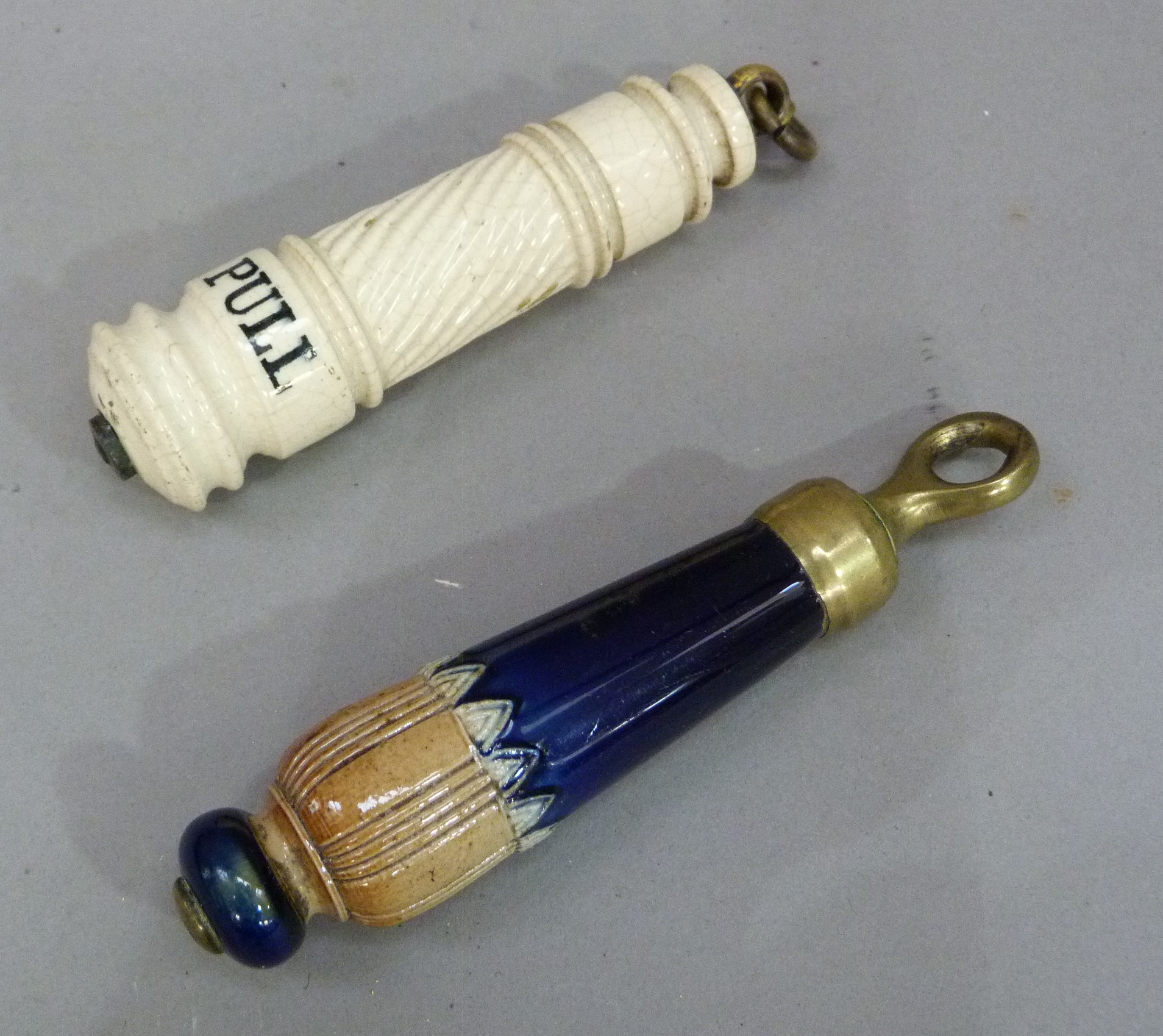 A Doulton stoneware light pull of tapered cylindrical form moulded with lappet band, brass capped,