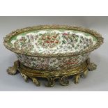 A reproduction pottery jardiniere decorated overall with fruiting branches beneath green scaled