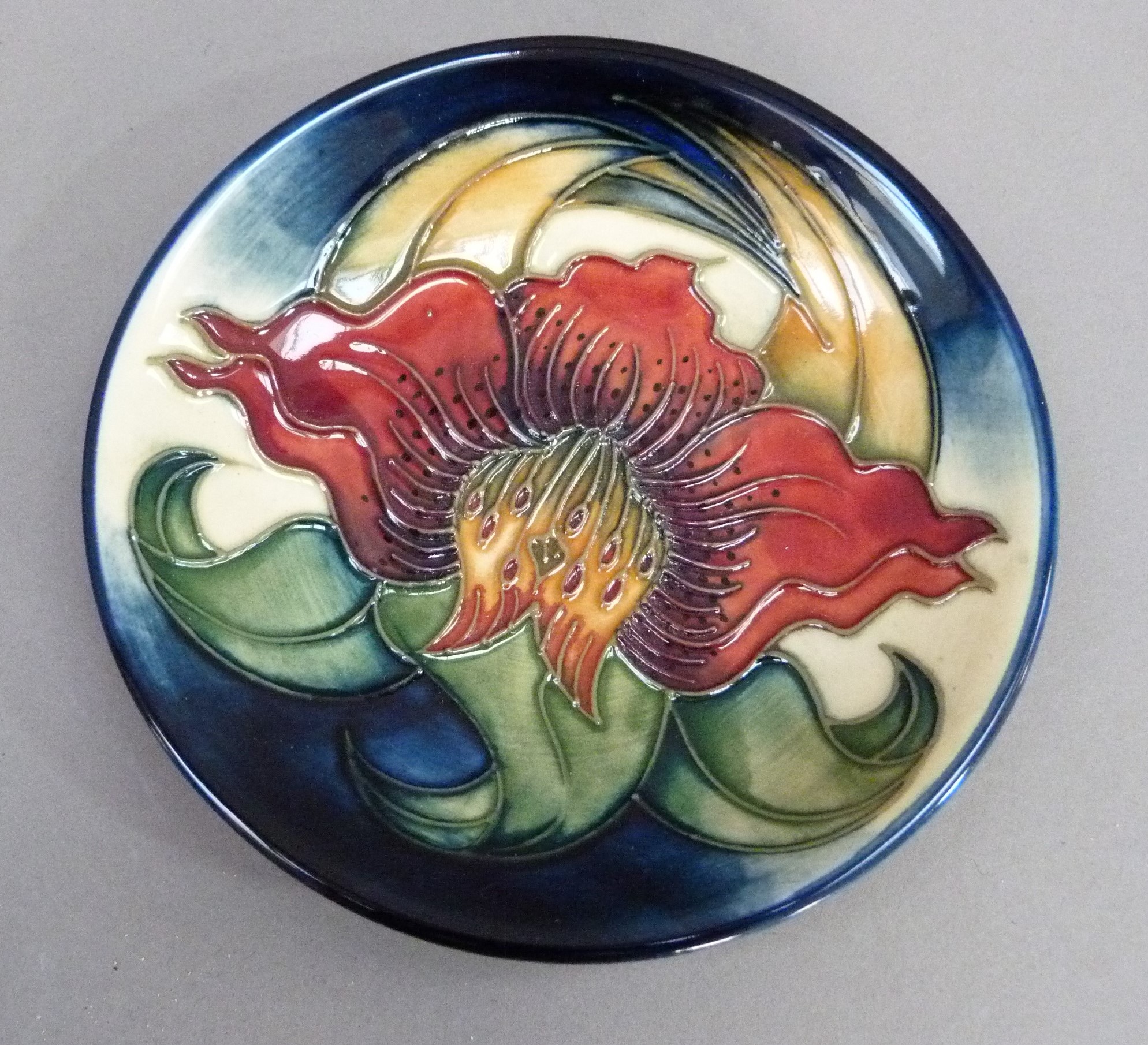 A Moorcroft Hibiscus pattern circular dish, 12cm diameter, impressed marks