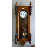 A 19th century walnut cased wall clock with fret cut pediment applied female mask, flanked by