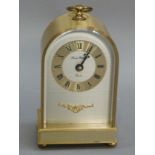 A London Clock Company mantel clock with brushed gilt arched case the silvered face with brass