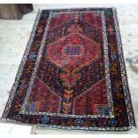 A Caucasian rug having a black field with crimson stepped medallion and corners filled with stylised