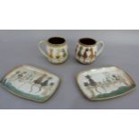 A pair of stoneglazed rounded rectangular dishes and two matching mugs decorated with cats on a