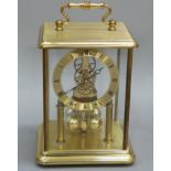 A reproduction brass cased four glass clock with brass chapter ring with Roman numerals, visible