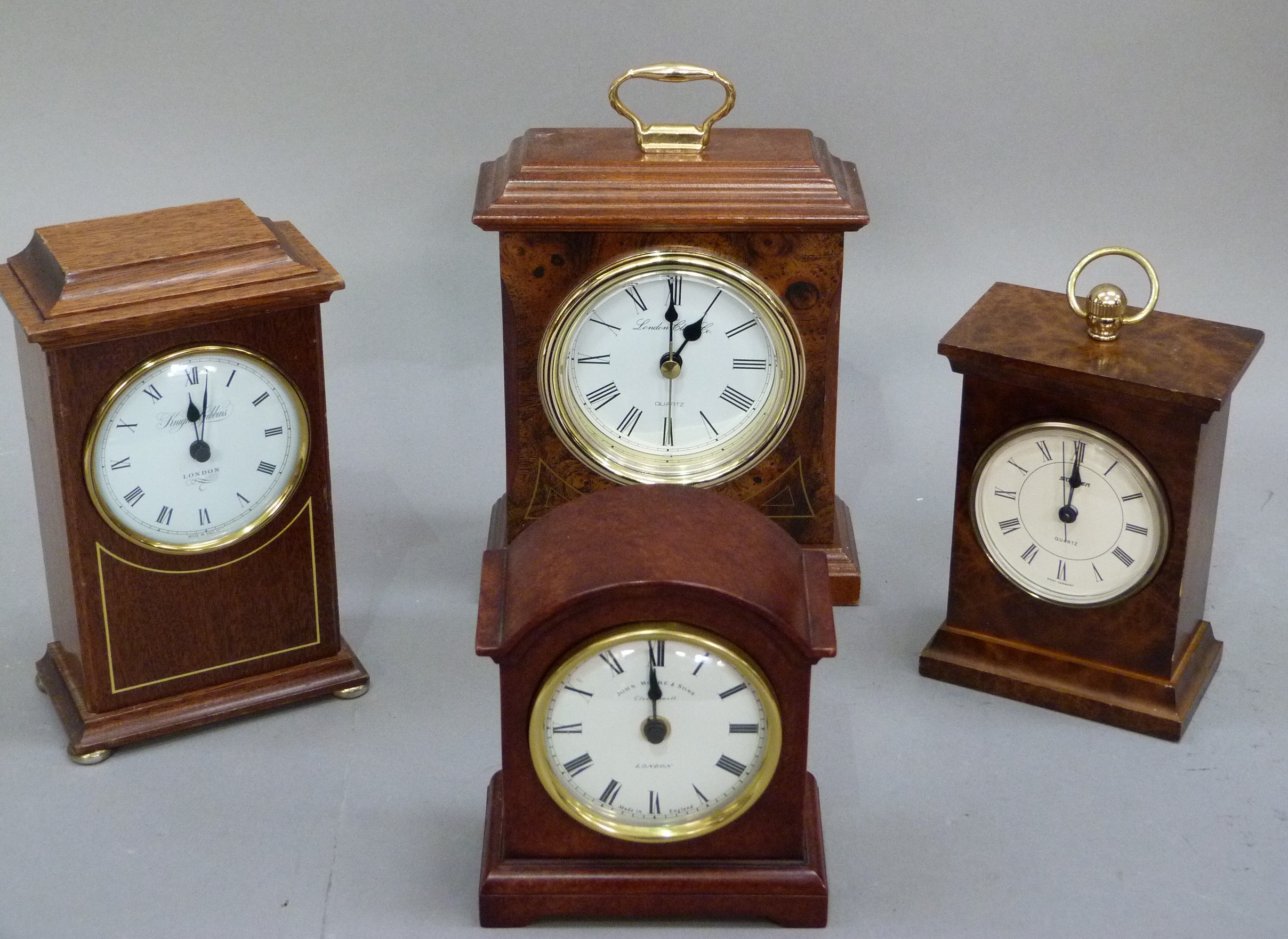 Four quartz mantel clocks in wooden and faux wooden cases, various makers, 21cm high and smaller