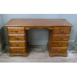 A reproduction pine twin pedestal desk the rectangular top above two banks of four drawers,