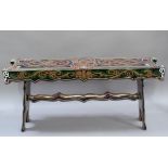 A decorative painted small bench with rectangular top with shaped frieze, trestle ends joined by a
