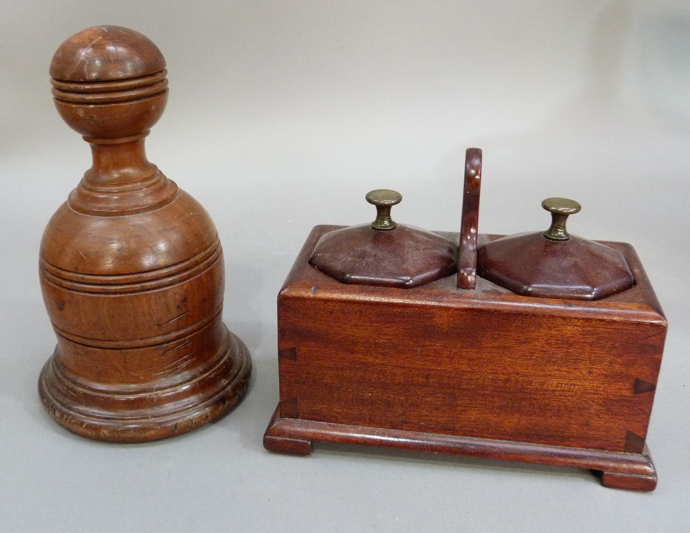 A turned wooden door porter with cast iron insert, bell shaped with reeded ball finial, 21cm high;