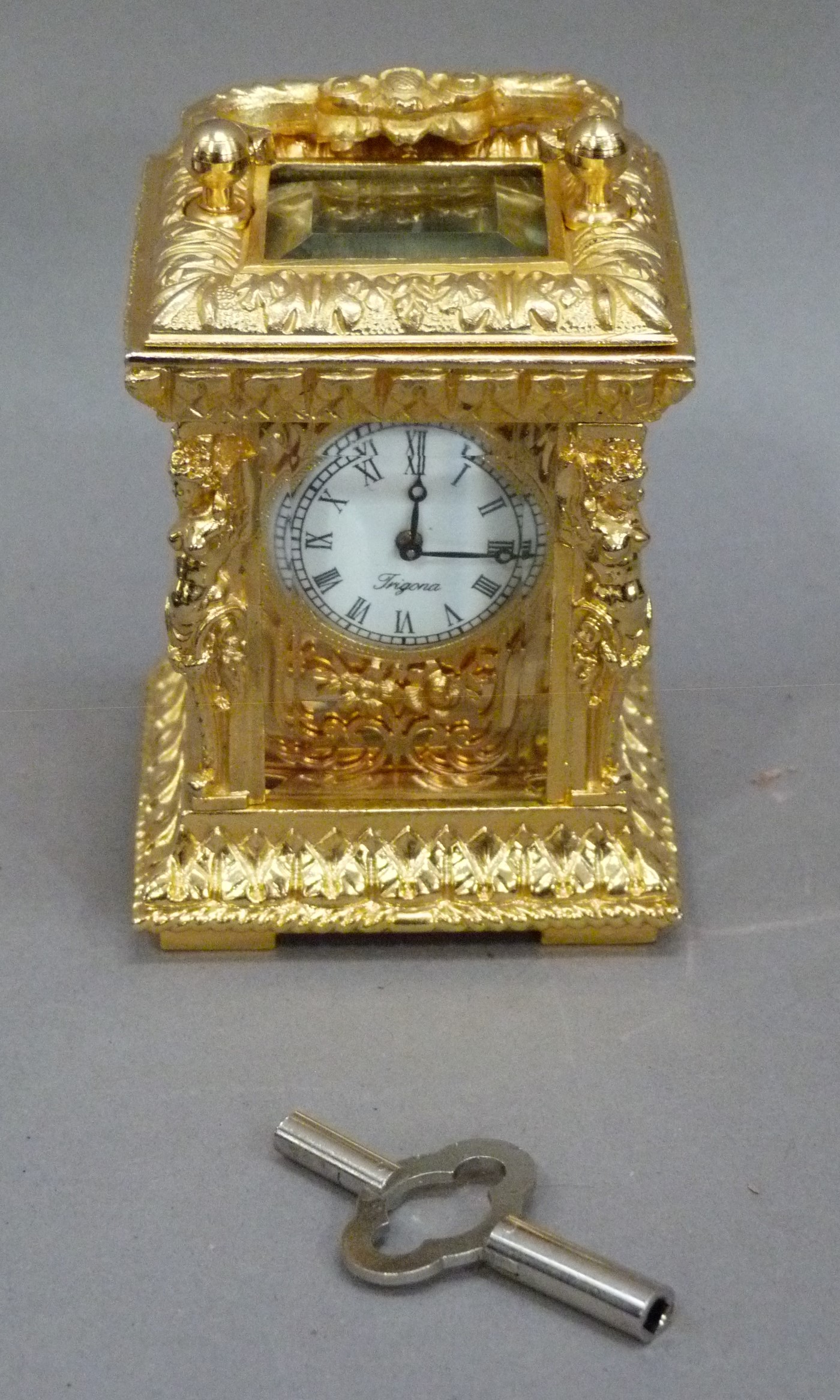 A reproduction gilt metal carriage clock in ornate Rococo case with foliate scroll carrying