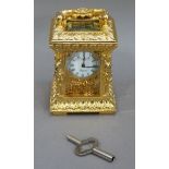 A reproduction gilt metal carriage clock in ornate Rococo case with foliate scroll carrying