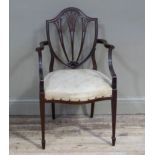 A pair of reproduction mahogany Hepplewhite style elbow chairs with shield shaped backs with