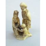 A soapstone carving of a bearded man, female and infant figure, 9.5cm high (a/f)