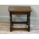 A reproduction oak stool in late 17th century style, the rectangular top with moulded lip above ring