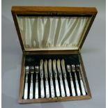 A set of six mother of pearl handled silver plated fish knives and forks in fitted walnut case