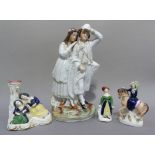A Staffordshire flatback figure of a young couple he with net over his right arm his left arm up,
