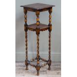 An oak two tier jardiniere stand the square top above a conforming undertier on baluster and