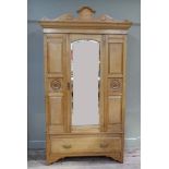 A late Victorian satin birch wardrobe with shaped cornice central bevelled mirror door flanked by