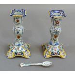 A pair of 19th century French faience candlesticks of baluster form on domed square bases