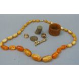 A string of amber type graduated beads, a coquilla napkin ring, various coins and gilt metal