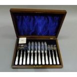 A set of mother of pearl handled silver plated fish knives and forks in fitted walnut case with