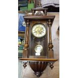 An early 20th century Vienna walnut wall clock with cream enamel chapter ring with Roman numerals,