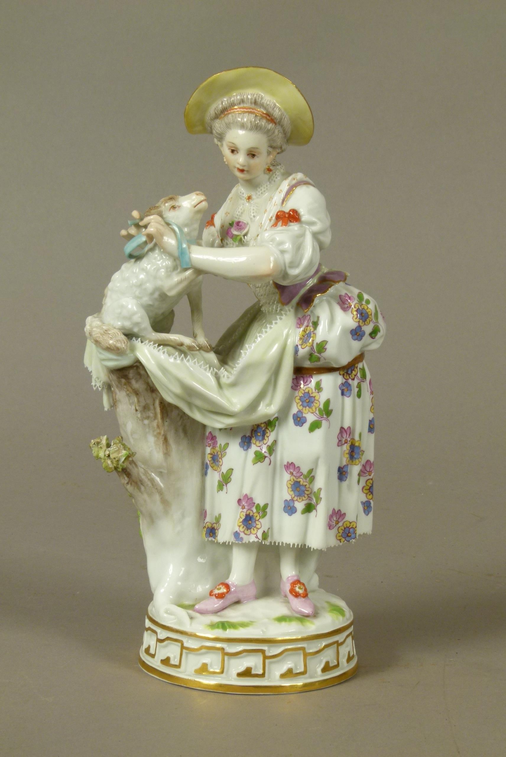 A Meissen figure of a shepherdess, tying a blue ribbon around a lamb's neck, circular base with gilt