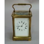 A lacquered brass cased carriage clock with bevelled glass plates, twin train movement striking on a