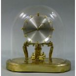 A Kieninger and Obergfell Kundo gilt metal and glass domed torsion clock 1958 silvered dial with