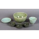 A Chinese celadon glazed tea bowl and saucer, the bowl with 'rice' decoration and incised lappet