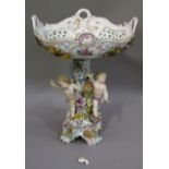 A continental porcelain floral encrusted centre piece, the four handled pierced oval top decorated