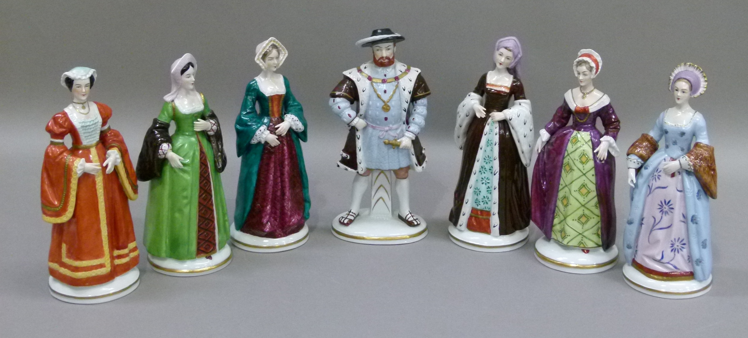 A set of seven porcelain figures of Henry VIII and his six wives, painted in colours, 21cm high,