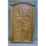 A Provence twin door wardrobe the arched cornice above a pair of raised fielded panelled doors,