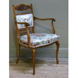 A late Victorian rosewood salon chair with foliate carved cresting rail above a panelled upholstered
