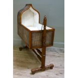 A Victorian mahogany framed and bergered rocking crib with lancet-shaped canopy, the interior with