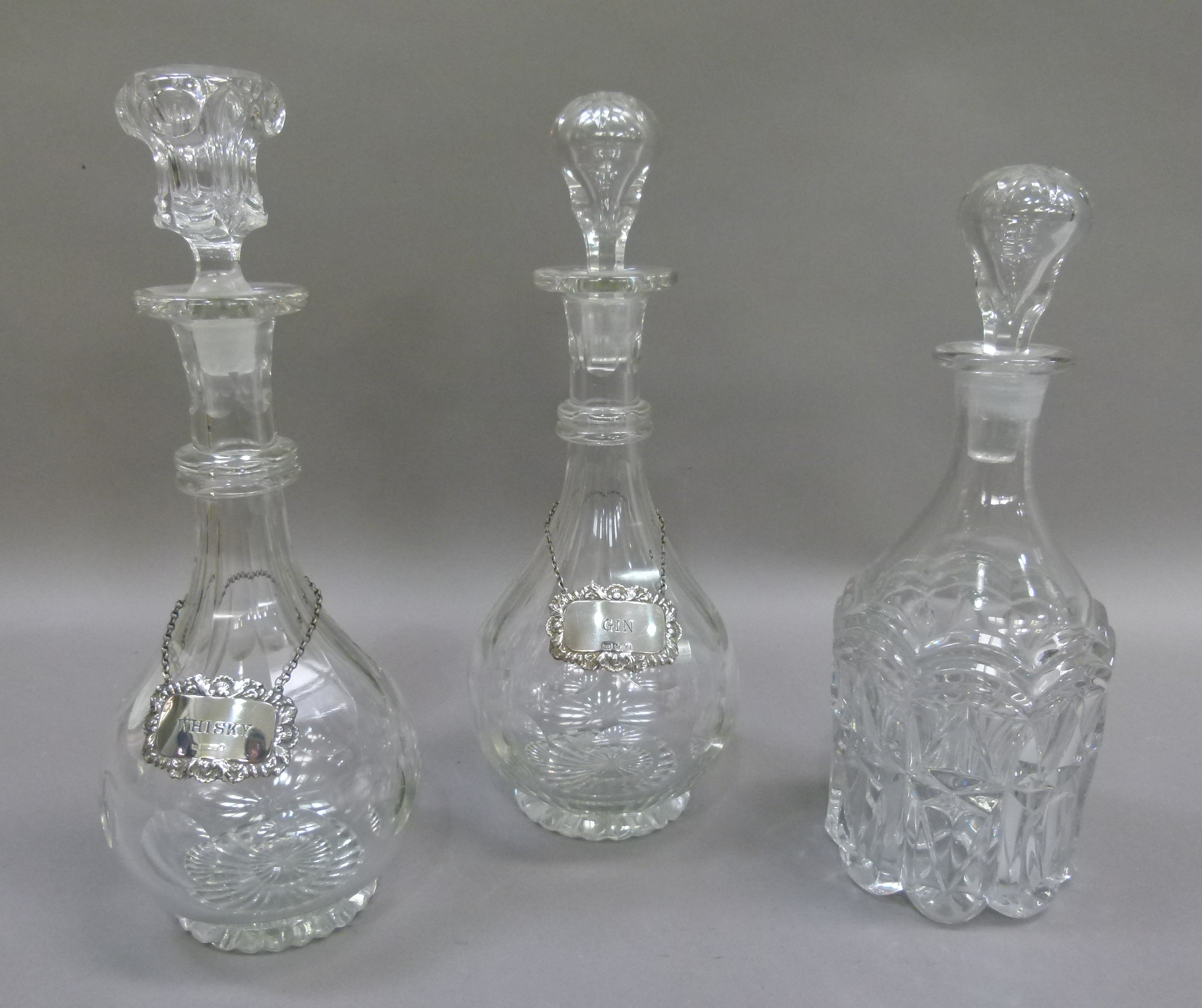 A pair of faceted baluster decanters with band of cut circles to the bodies, double ringed necks and