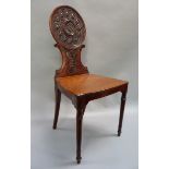 A 19th century mahogany hall chair the back with Guilloché roundel centered on a male head with