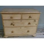 A pine chest of two short over two long graduated drawers, compressed bun feet, turned wooden