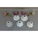 Seven frilled glass light shades, two cranberry tinted, together with two pink tinted frosted