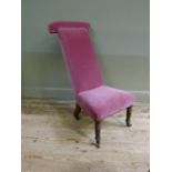 A Victorian mahogany framed Prie Dieu upholstered in pink velvet on turned legs fitted brass sockets